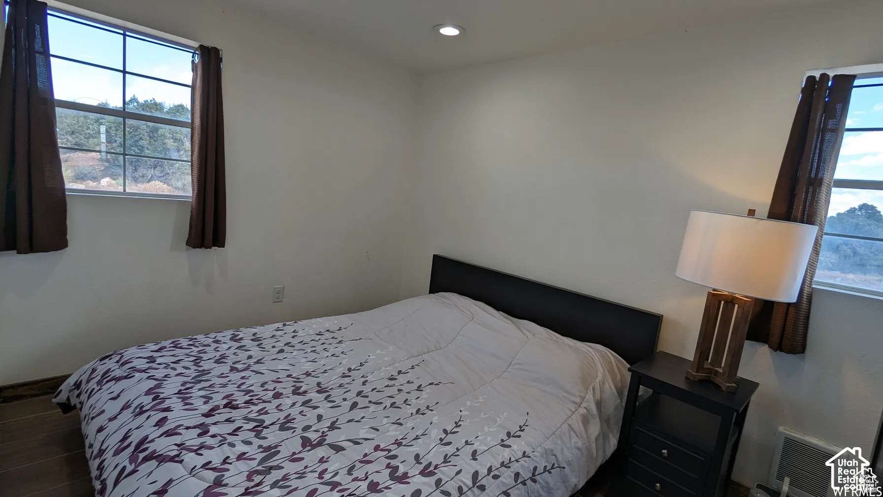 Room featuring dual grid-pattern windows, wood-finish flooring, and recessed ceiling lighting