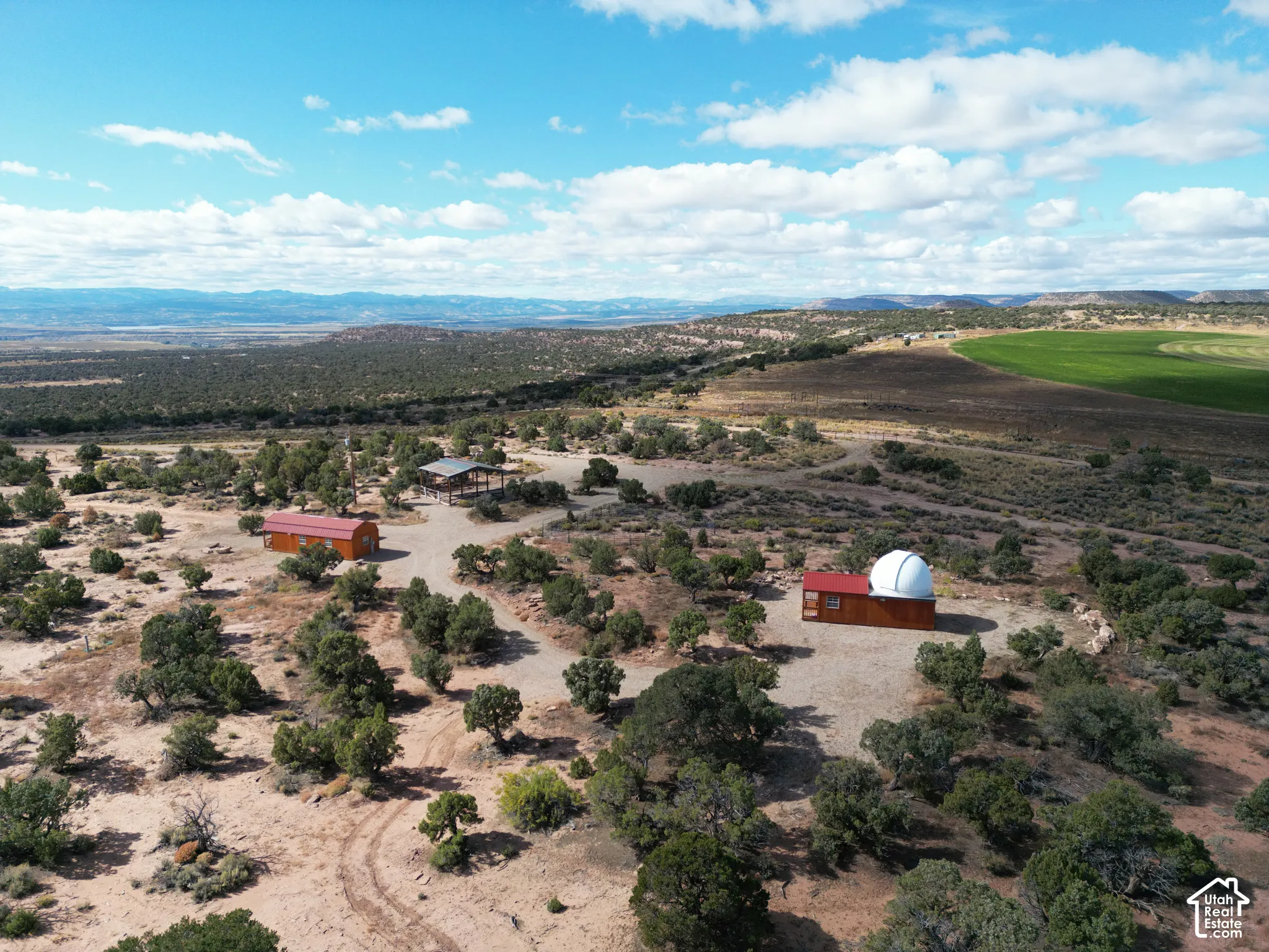 Expansive acreage featuring multiple structures, an observatory dome, a covered pavilion, and native desert terrain