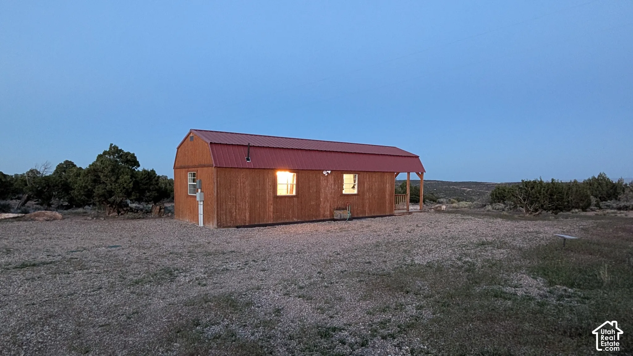 Barn-style structure featuring wood-panel siding, a metal roof, and an integrated porch