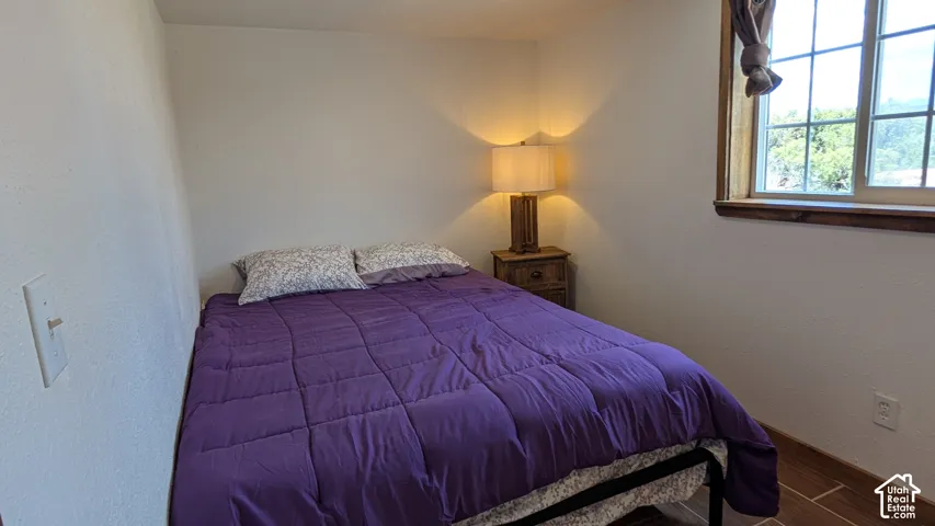 Room featuring wood-finish tile flooring and a multi-pane window with wood-trim framing