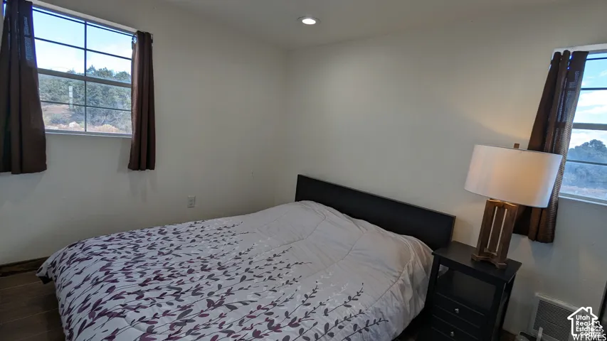 Room featuring dual grid-pattern windows, wood-finish flooring, and recessed ceiling lighting
