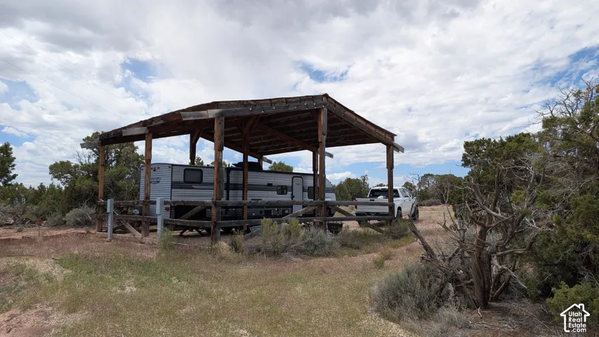 Covered timber-frame structure featuring a wooden post-and-beam support system and perimeter fencing