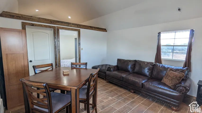 Vaulted ceilings featuring decorative natural wood trim and recessed lighting, paired with wood-finish tile flooring throughout