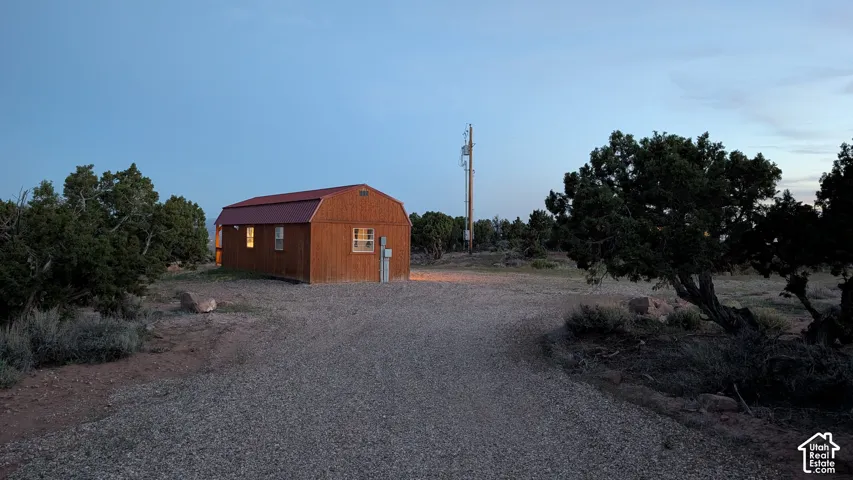Wood-sided exterior cabin with a red metal roof and gravel lot