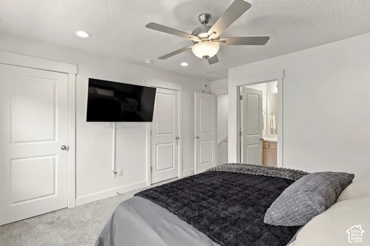 Neutral-toned interior featuring recessed lighting, a brushed nickel ceiling fan with an integrated light kit, crisp white panel doors, and neutral wall-to-wall carpeting