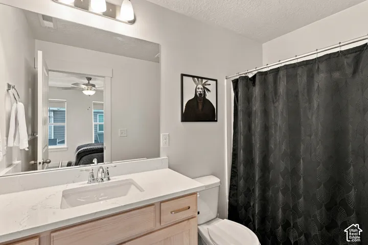 Bathroom featuring a light wood vanity with a white countertop, an integrated rectangular sink, a polished chrome widespread faucet, and a large wall-mounted mirror