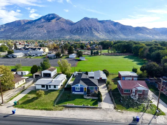 Single-story residence featuring a blue exterior, a detached garage, and a mountain backdrop