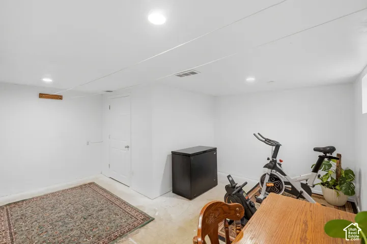 Neutral interior room featuring white walls, recessed ceiling lighting, and a six-panel interior door