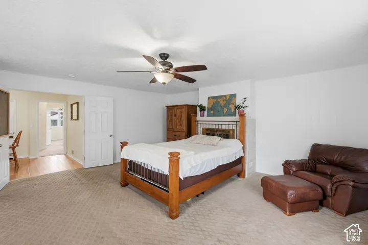 Spacious room featuring neutral carpeting, a ceiling fan with integrated lighting, and a white interior door