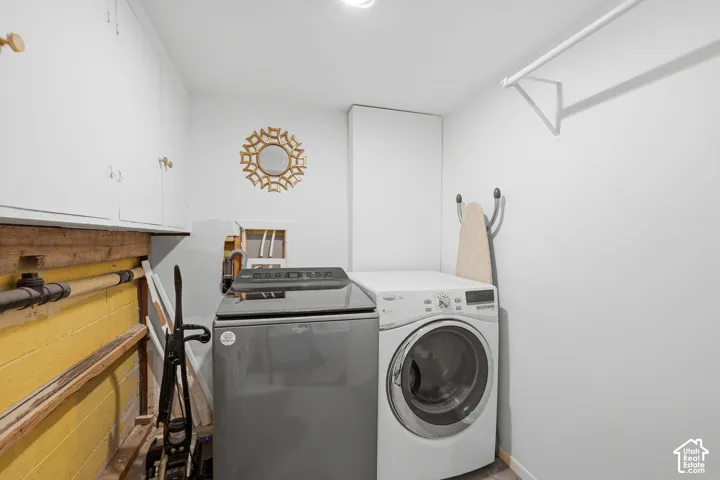 Laundry area featuring upper storage cabinetry and a mounted wall rod