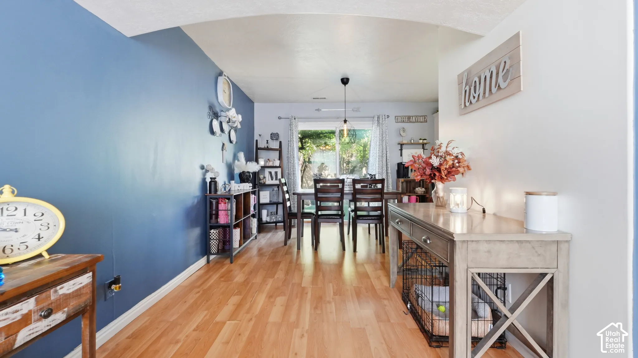 Wood-finish flooring, accent wall, arched ceiling detail, and sliding glass door