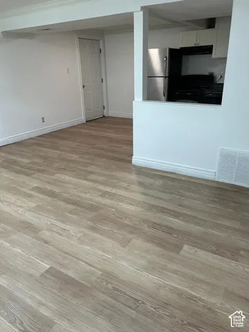 Open-concept interior featuring wood-finish flooring, a pass-through wall, built-in cabinetry, and stainless steel appliances