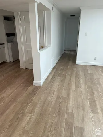 Interior space featuring wood-finish flooring, a half-wall architectural partition, and neutral wall tones
