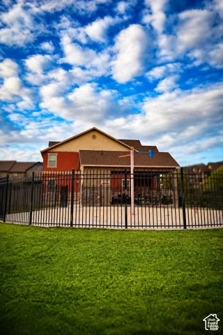 Fenced outdoor space featuring a paved water feature and covered picnic area