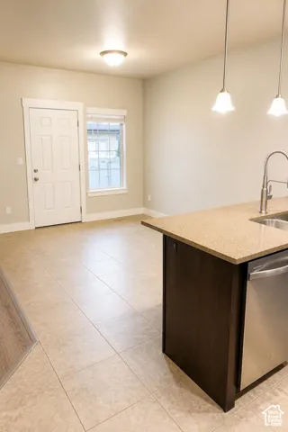 Kitchen featuring dining area, dark cabinetry, granite countertops, stainless steel appliances, recessed ceiling lighting, and pendant fixtures