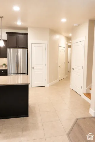 Kitchen featuring dark cabinetry, granite countertops, stainless steel appliances, recessed ceiling lighting, and pendant fixtures