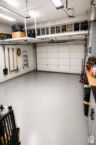 Finished garage, thoughtfully upgraded with insulation, heating and cooling, professional lighting, overhead storage, and a foldable 16-foot workbench.