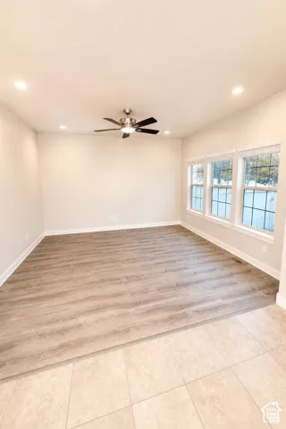 Living Room featuring wood-finish flooring, recessed lighting, a brushed-metal ceiling fan with integrated lighting, and three multi-pane windows with white trim