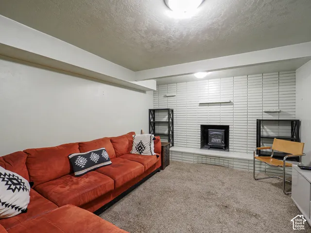 Floor-to-ceiling white brick wall featuring an inset fireplace and elevated concrete hearth
