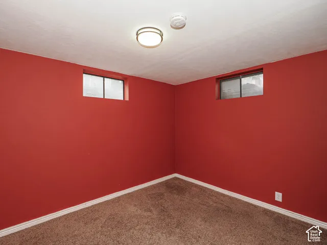 Room featuring wall-to-wall carpeting, two elevated windows, and a flush-mount ceiling light fixture