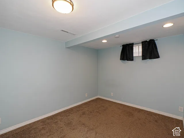 Neutral interior space featuring carpeted flooring, recessed lighting, a flush-mount ceiling fixture, and a single window