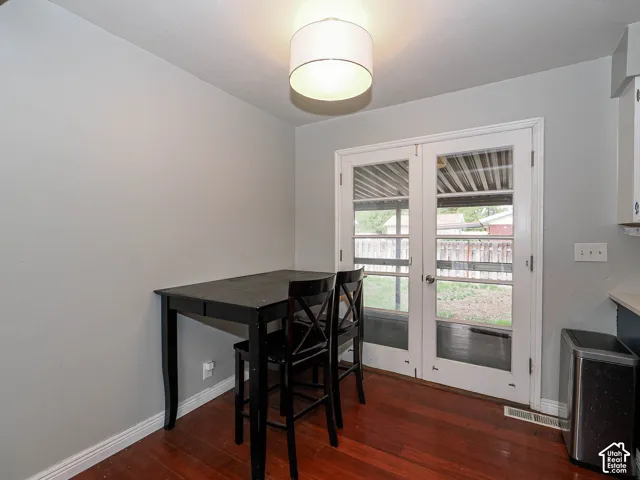Wood-finish flooring, glass-paneled double doors, and a drum-style pendant light fixture
