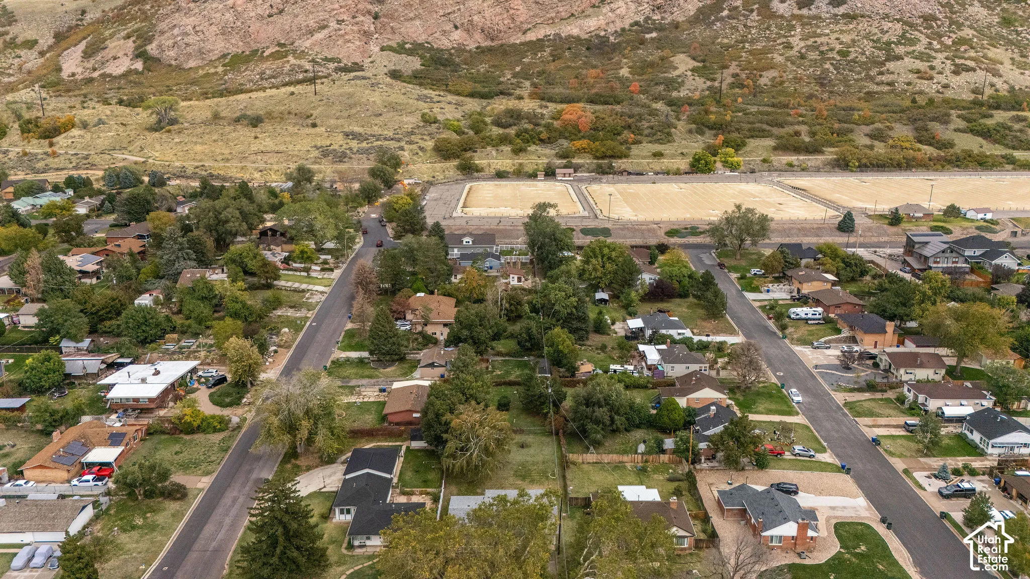 Aerial perspective featuring a hillside backdrop and mature tree-lined residential streets