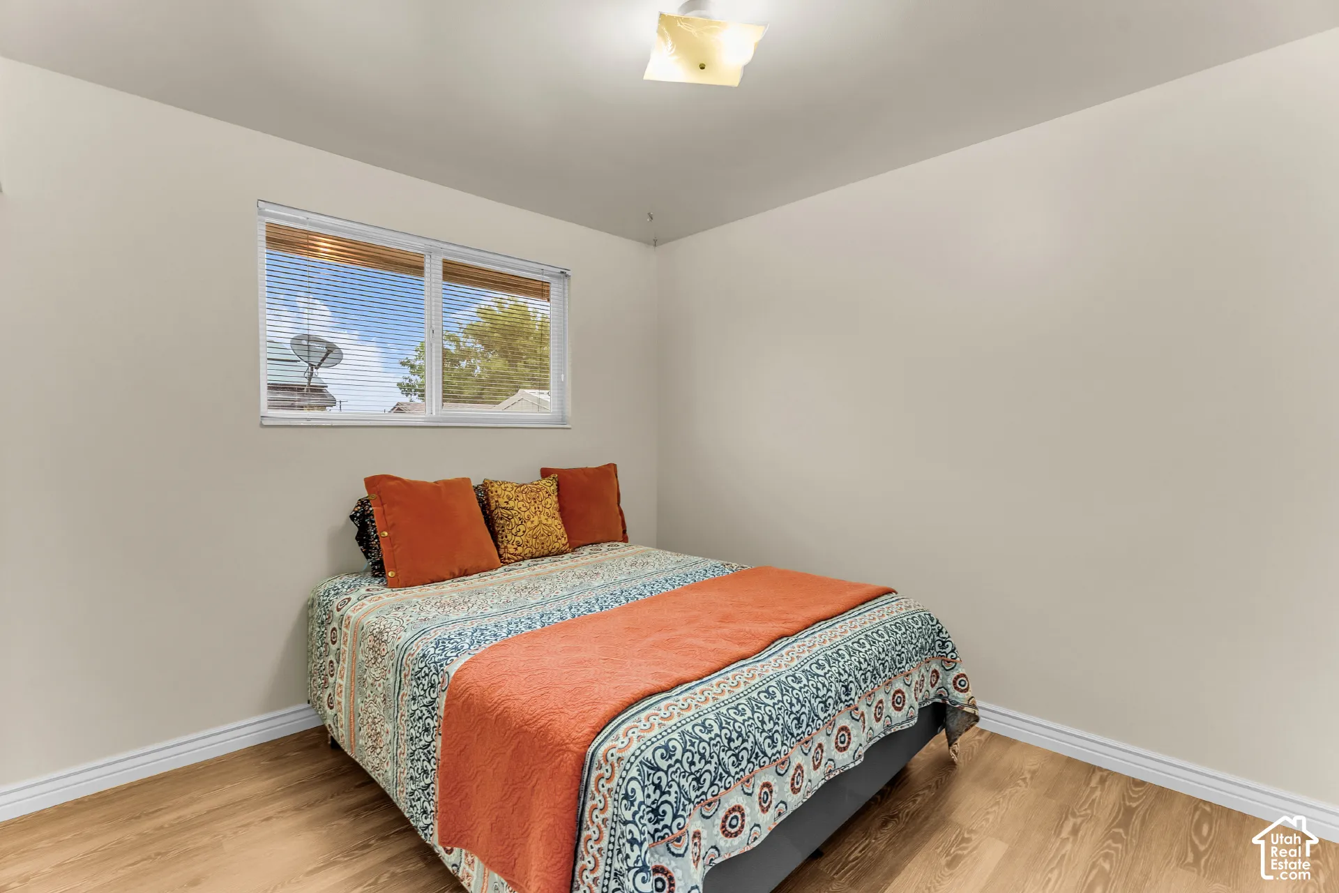 Neutral wall finishes, wood-finish flooring, sliding glass window, and flush-mount ceiling light fixture