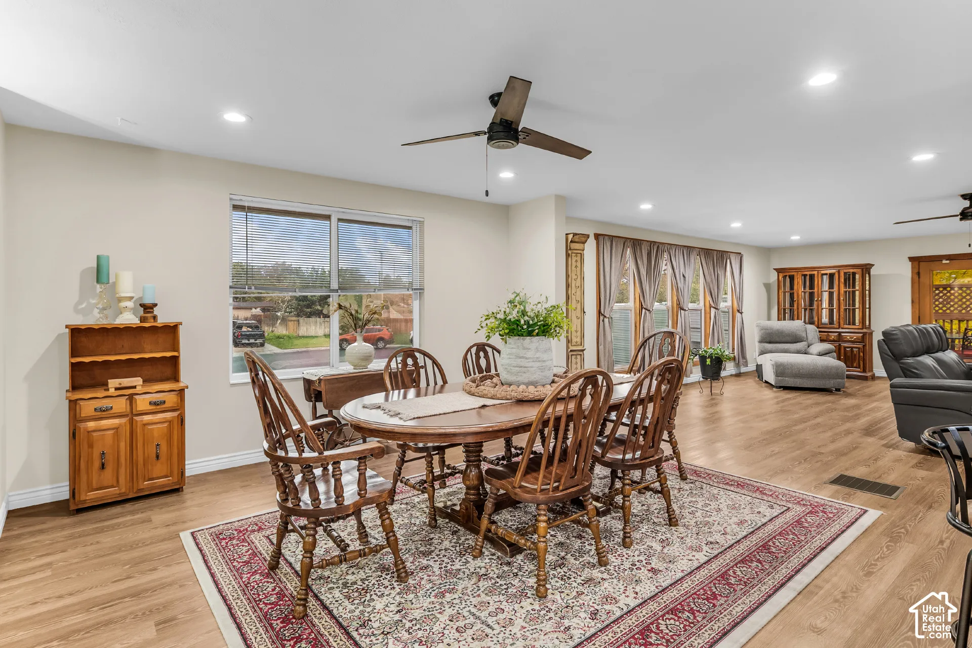 Open-concept space featuring wood-finish flooring, recessed lighting, ceiling fans, and large windows with natural light