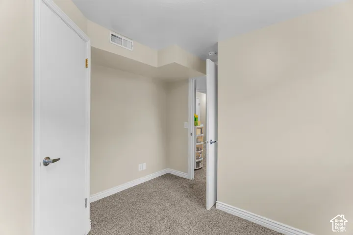 Neutral wall paint, plush carpeting, and solid-core interior doors with metallic lever handles
