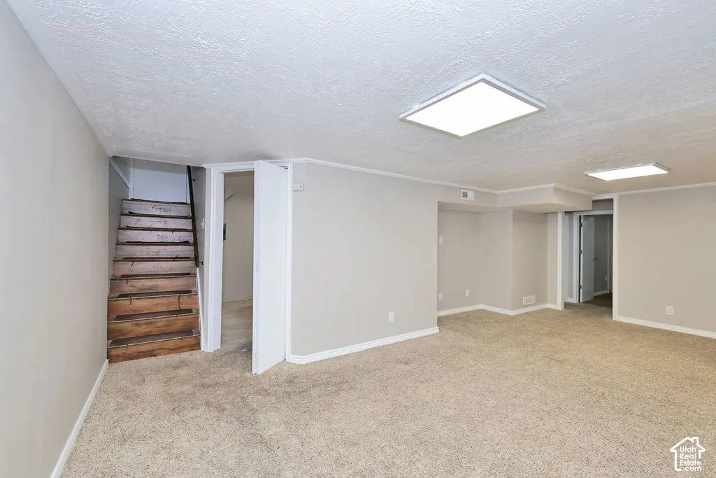 Open-concept room featuring neutral-toned carpeting, square recessed ceiling lighting, and wooden stair treads