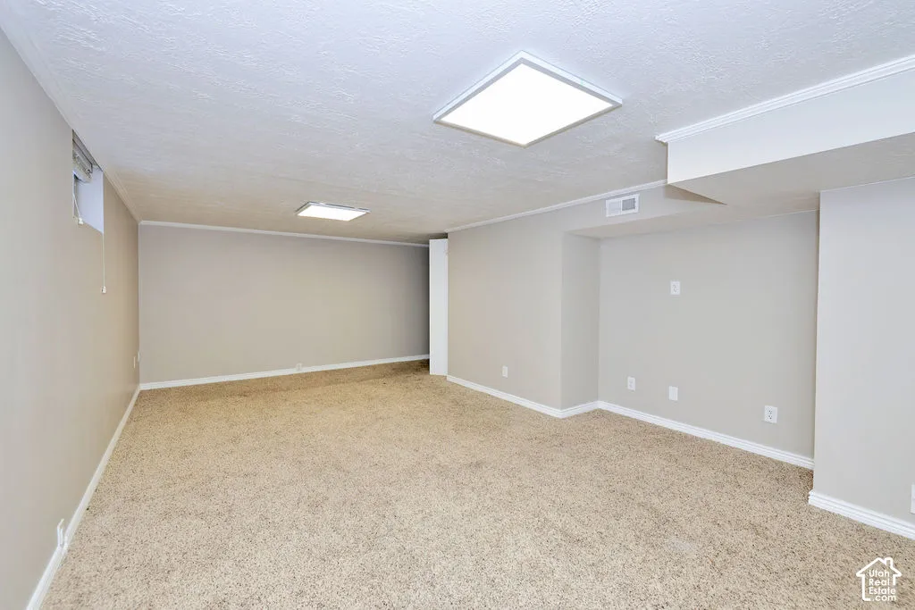 Neutral-toned interior space featuring neutral carpeting, recessed square LED lighting fixtures, and inset wall niches