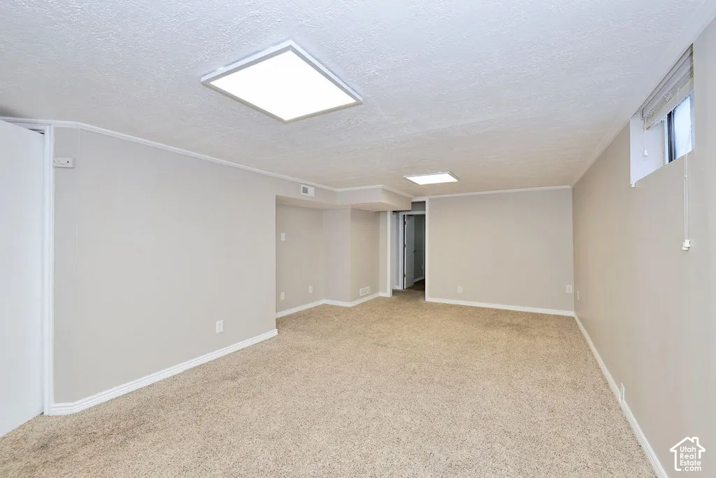 Open interior space featuring neutral wall tones, wall-to-wall carpeting, and recessed square LED lighting fixtures