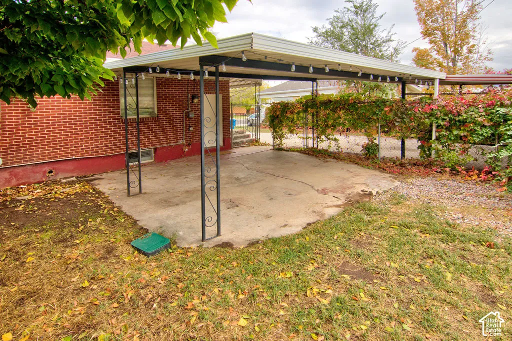 Red brick exterior featuring a concrete carport with decorative metal supports