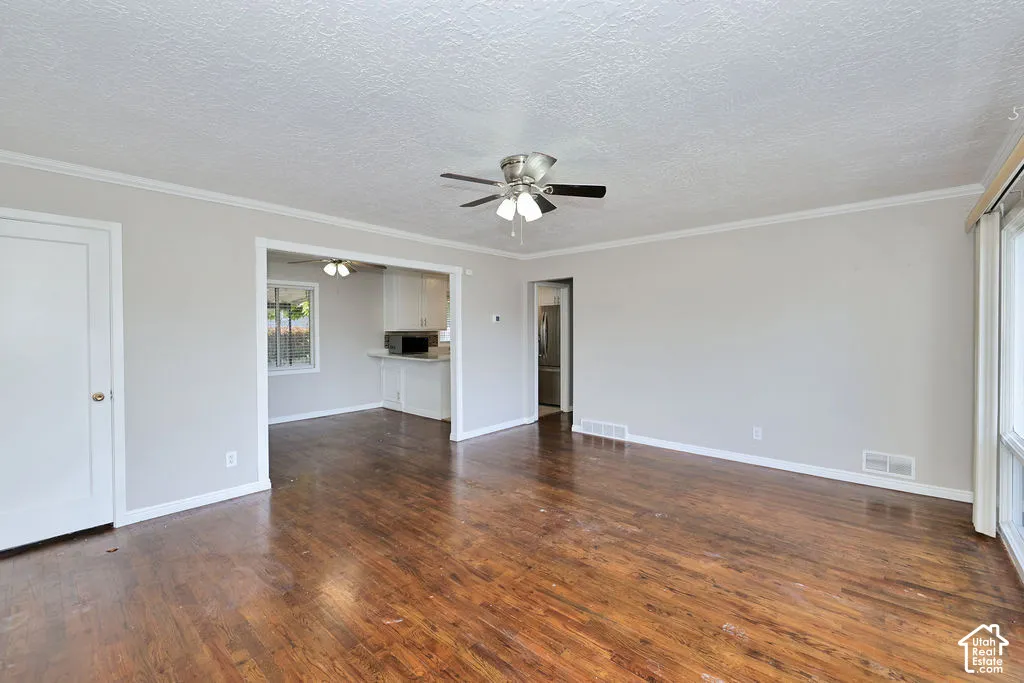 Interior space featuring dark wood-finish flooring, neutral wall paint, and a ceiling-mounted light fixture with a fan