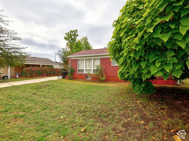 Red brick exterior featuring a multi-pane window configuration and concrete driveway
