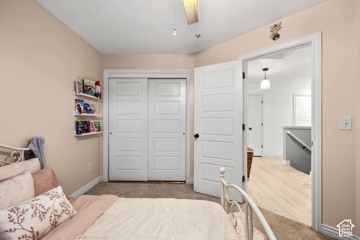 Room featuring five-panel interior doors, wall-mounted floating shelving, and a ceiling fan with light fixture