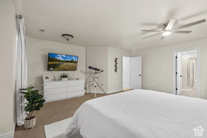 Neutral-toned interior featuring carpeting, a multi-blade ceiling fan with integrated lighting, and multi-panel interior doors
