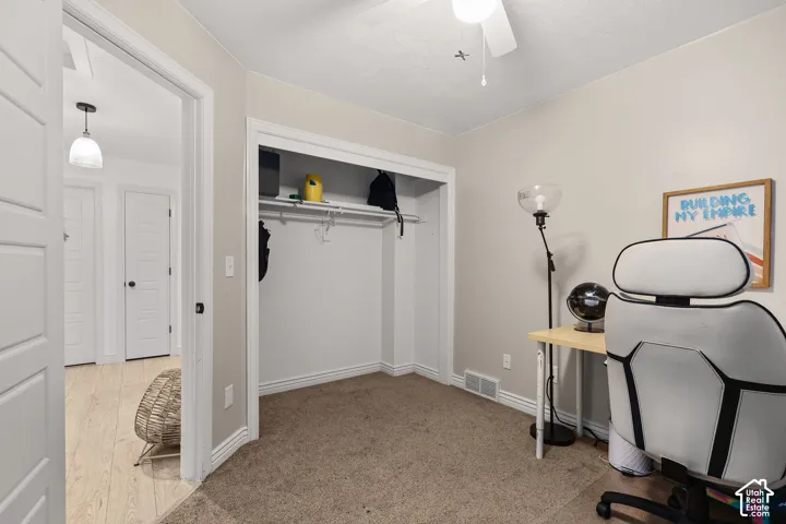 Room featuring neutral-toned carpeting, a built-in closet with overhead shelving, a ceiling-mounted light fixture, and classic white interior doors