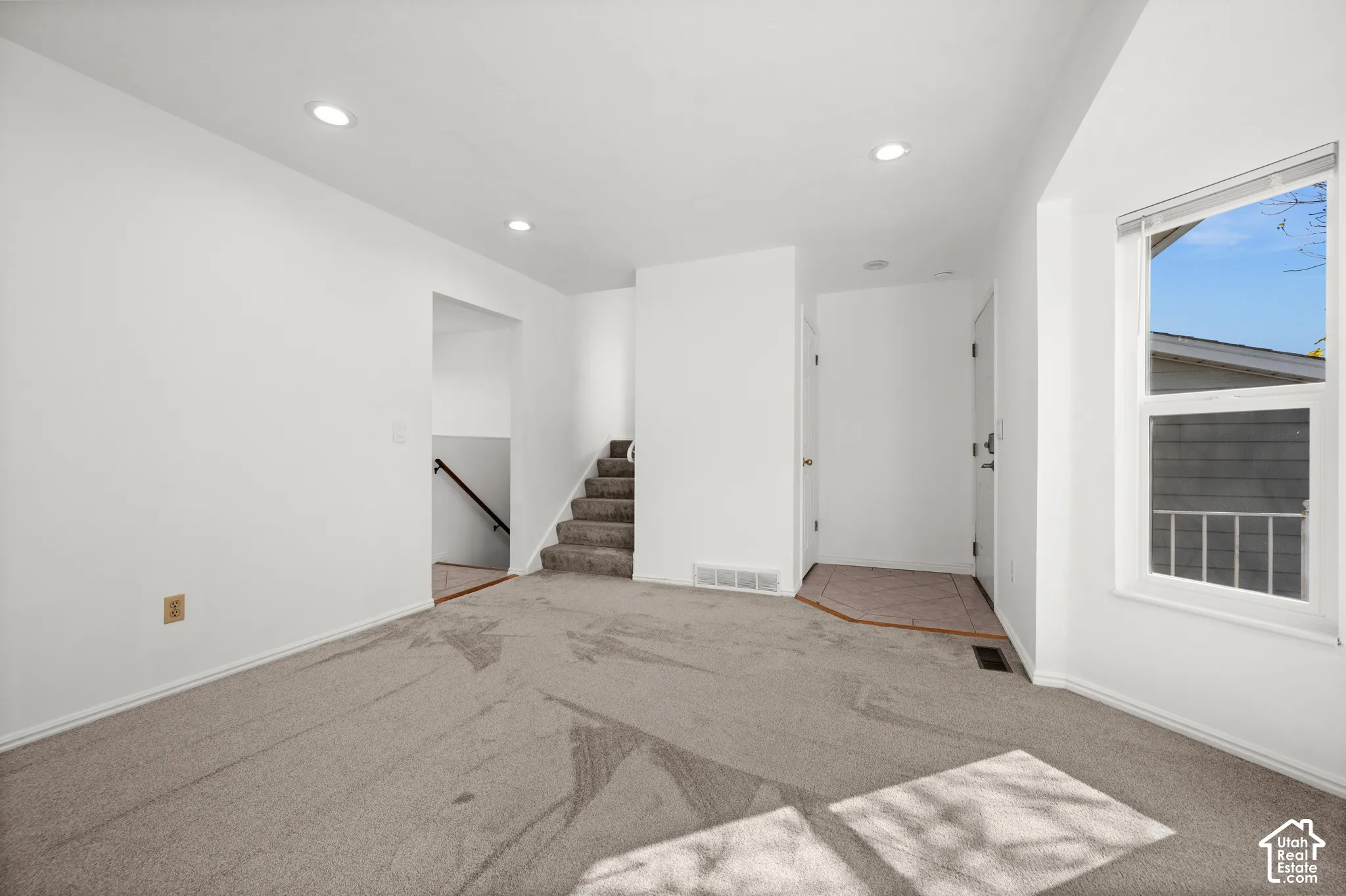 Neutral-toned carpeting, recessed ceiling lighting, and a single-hung window