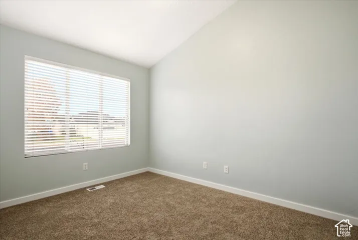 Vaulted ceiling, neutral wall tones, and horizontal window blinds