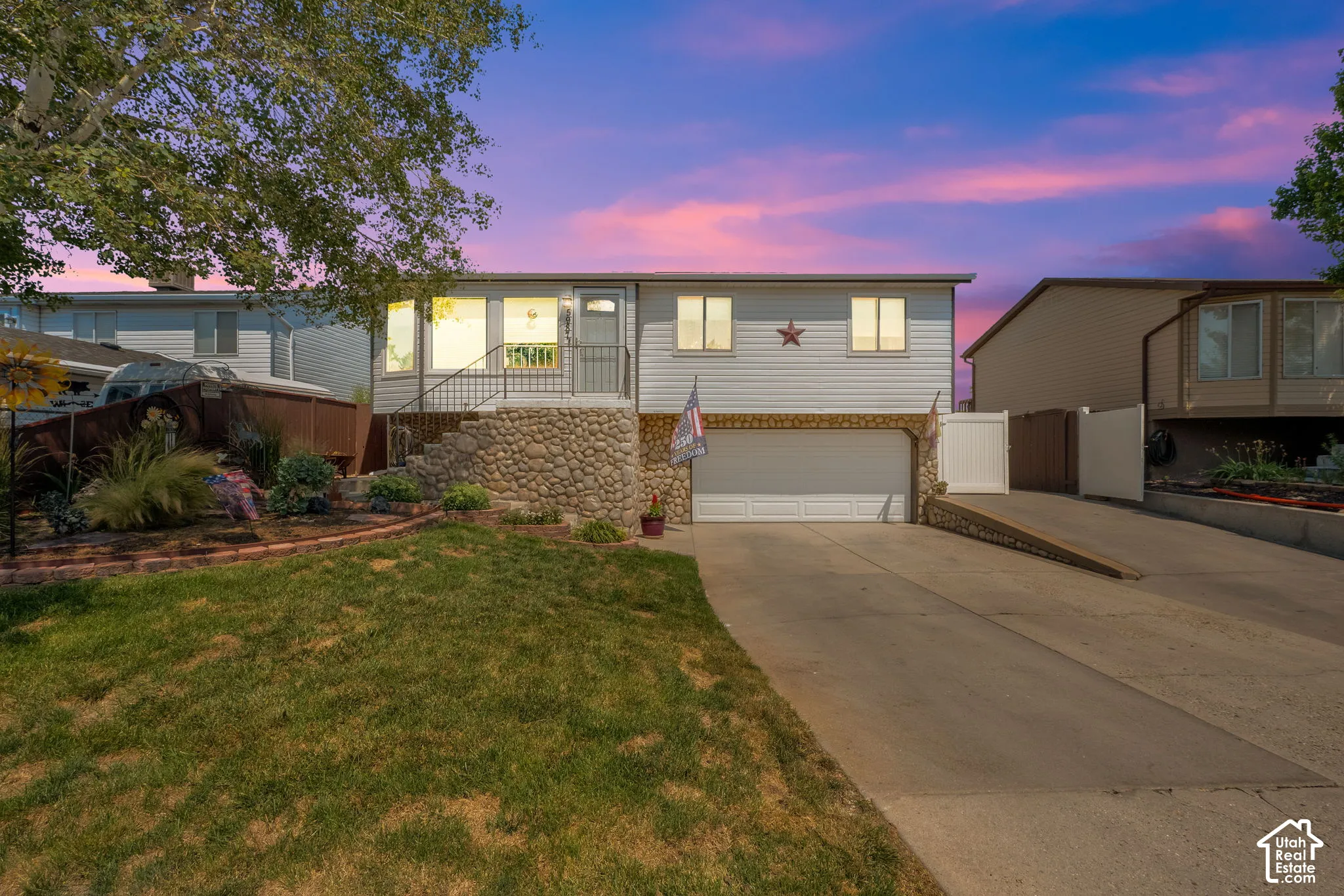 Rambler, exterior featuring horizontal siding, a river rock stone facade, a multi-car garage, and concrete driveway