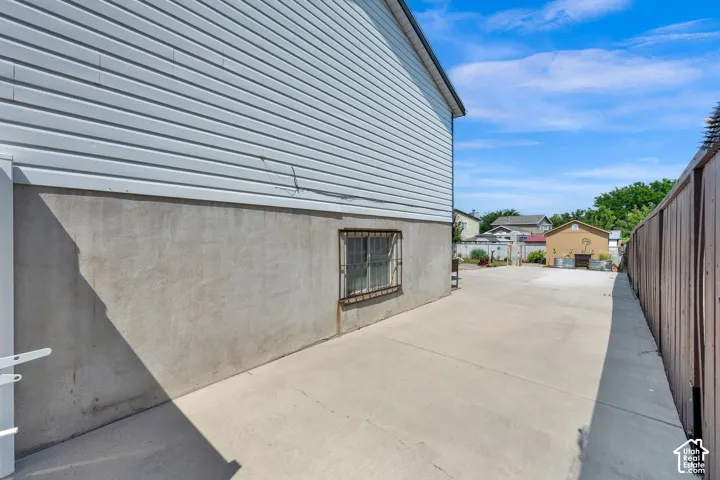 Side exterior featuring horizontal siding, concrete foundation,  and large area for RV parking