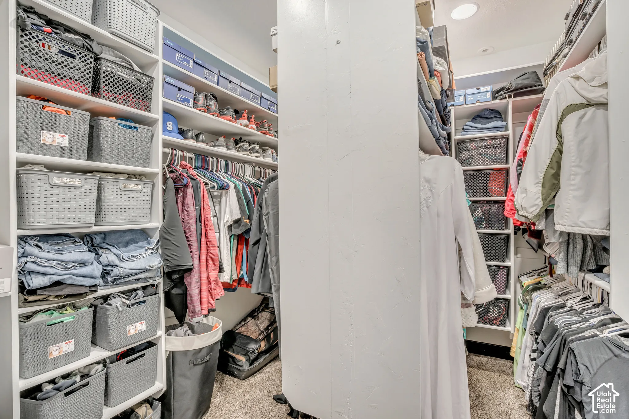 Walk-in closet featuring extensive built-in white shelving, multiple hanging rods, and recessed ceiling lighting