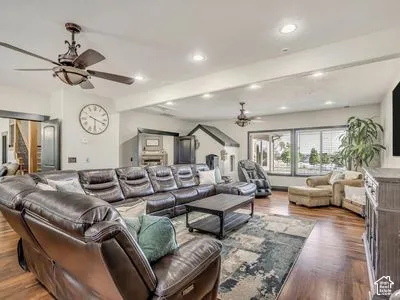 Open-concept living space featuring wood-finish flooring, dual ceiling fans, and recessed lighting