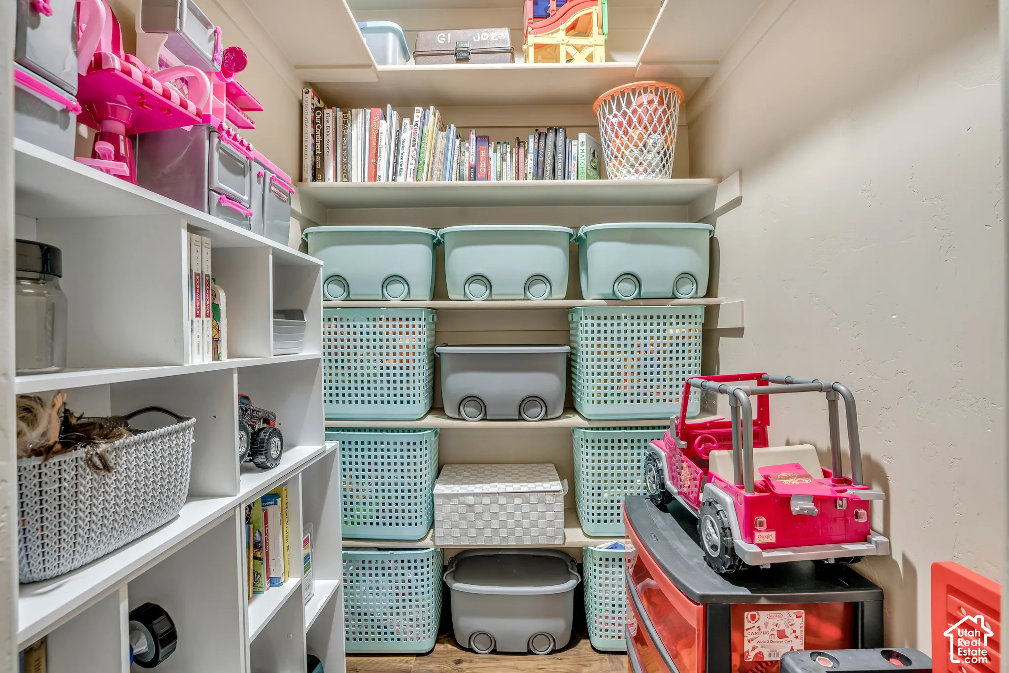 Built-in storage closet featuring tiered white shelving and a custom cubby organization system