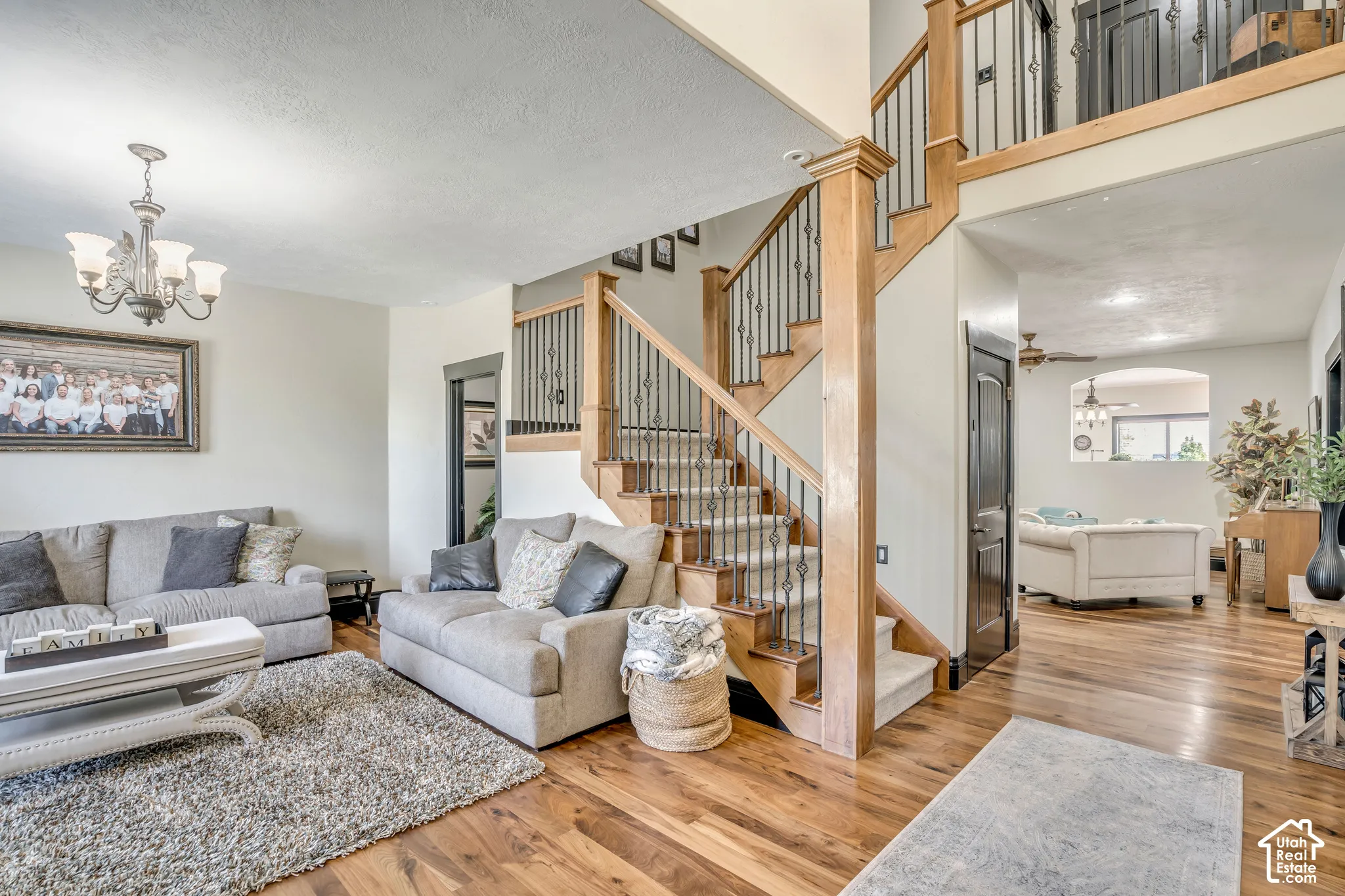 Staircase featuring wood handrails, decorative metal balusters, and carpeted treads