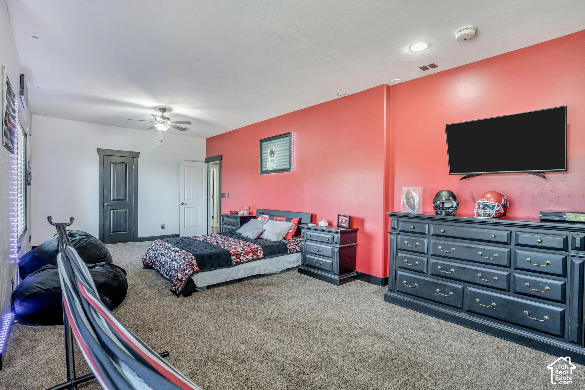 Spacious room featuring carpeting, recessed lighting, a ceiling fan, and bold accent wall painting