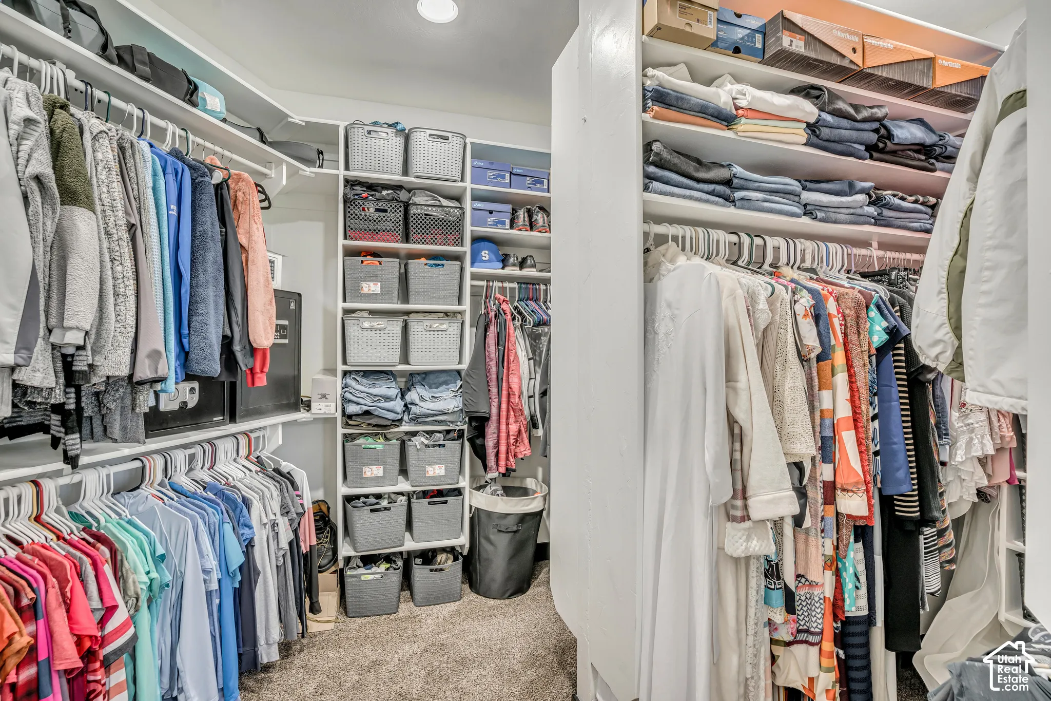 Walk-in closet featuring floor-to-ceiling custom shelving, multiple tiers of hanging rods, and integrated overhead storage cubbies