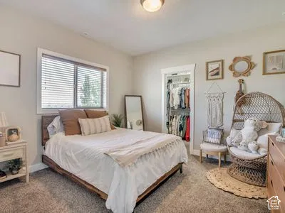 Neutral-toned interior featuring wall-to-wall carpeting, a horizontal sliding window, and a reach-in closet with built-in wire shelving